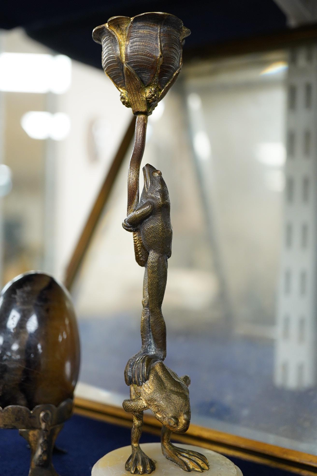 A Blue John egg, on white metal stand, an ormolu and alabaster candlestick cast as frogs, 18cm high, a French champleve, ormolu and alabaster holy water stoup and a gilt brass easel-back photograph frame